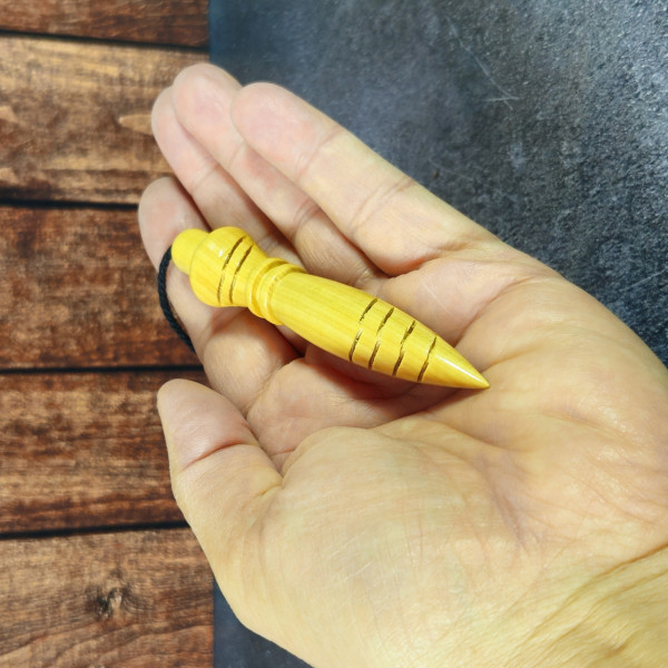 Pendule Thot en buis artisanal avec cordon noir, posé en vue horizontale