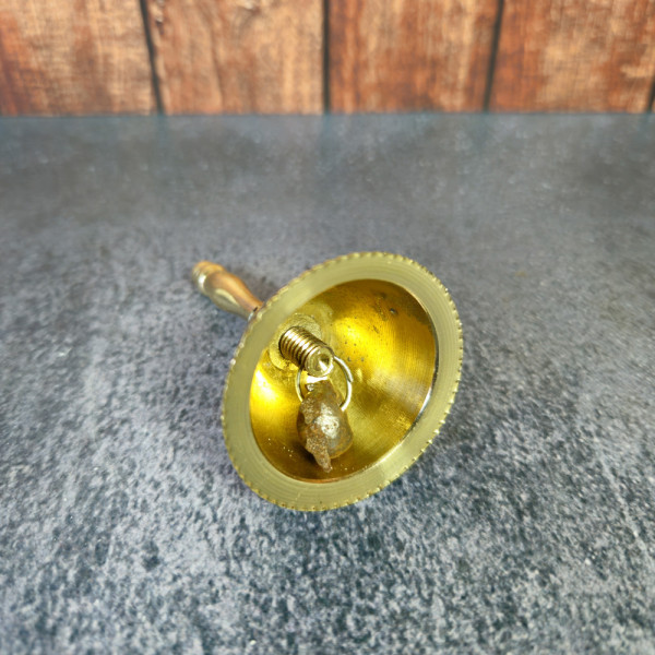 Vue rapprochée de l’intérieur de la cloche rituelle en laiton, diffusion homogène des vibrations