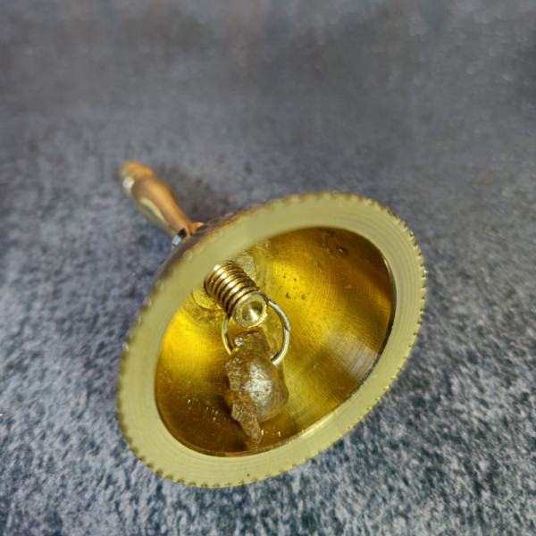 Gros plan sur le battant de la clochette d’autel, idéal pour ouvrir et fermer un rituel spirituel