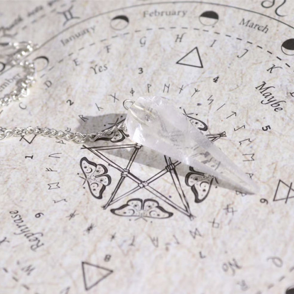 Pendule cristal de roche pour divination avec carte radiesthésie dans rituel purification énergétique