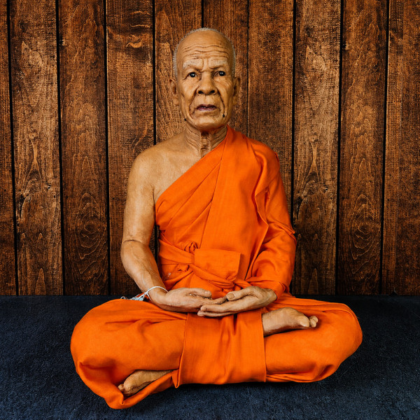 Moine en cire Luang Phor Sodh, statue thaïlandaise hyperréaliste en robe orange, vue de face