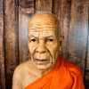 Visage hyperréaliste du moine Luang Phor Sodh en cire, détail des traits et de l’expression