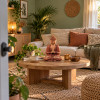 Bouddha de l’accueil en bois de suar sur une table basse en bois, dans un salon zen Maison Namaste
